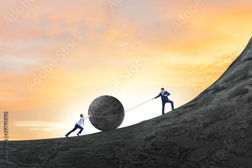 Bild auf Leinwand Teamwork example with business people pushing stone to top