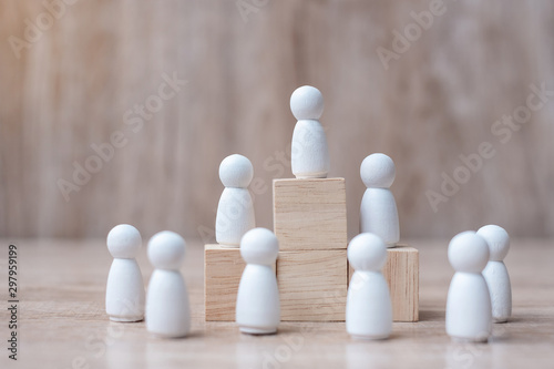hand holding top of businessman leader with crowd of wooden men. leadership  business  team  teamwork and Human resource management concept