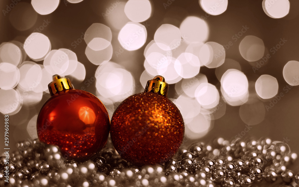 Two Christmas ornaments lying on balls of a Christmas chain on a blurred background with lights. Two Christmas ornaments lying on balls of a Christmas chain on a blurred background with lights.