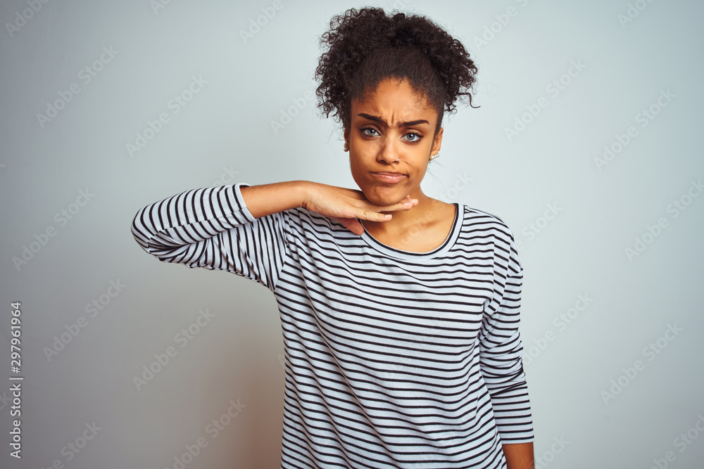 African american woman wearing navy striped t-shirt standing over isolated white background cutting throat with hand as knife, threaten aggression with furious violence African american woman wearing navy striped t-shirt standing over isolated white background cutting throat with hand as knife, threaten aggression with furious violence