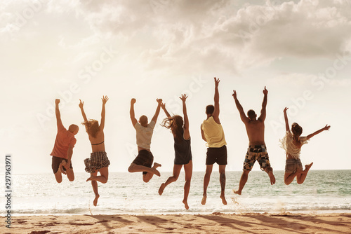 Happy friends jumps together at sea beach