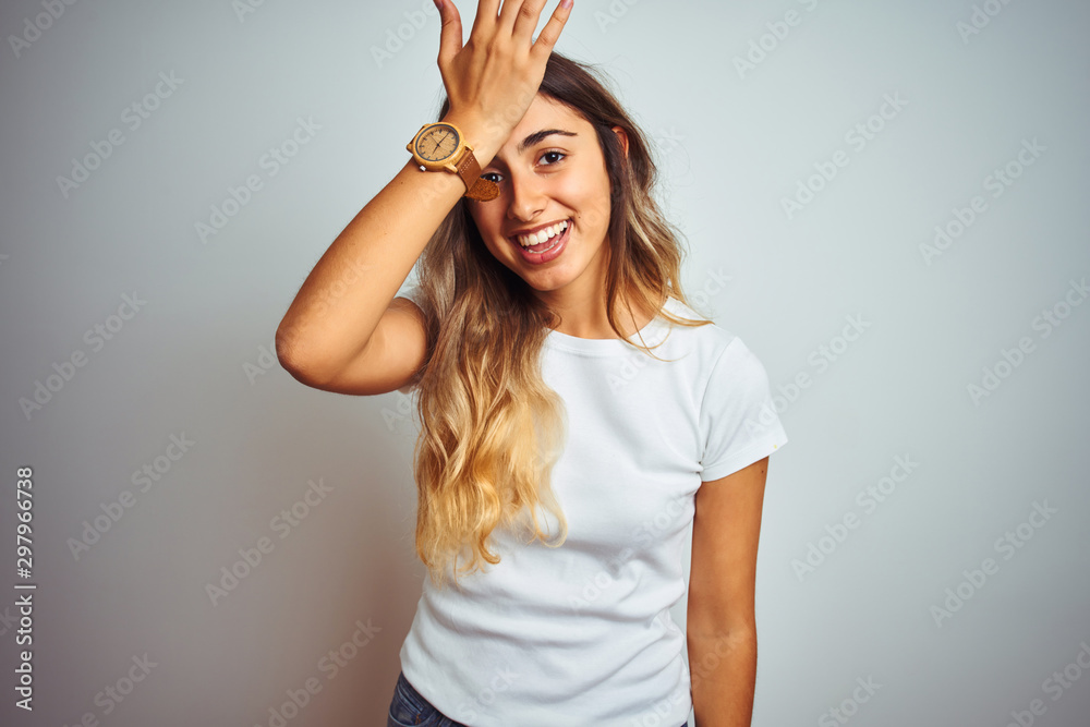 Young beautiful woman wearing casual white t-shirt over isolated background surprised with hand on head for mistake, remember error. Forgot, bad memory concept.