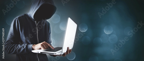 Hacker with laptop. Computer crime.
