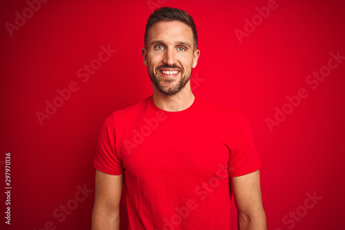 Young handsome man wearing casual t-shirt over red isolated background with a happy and cool smile on face. Lucky person.