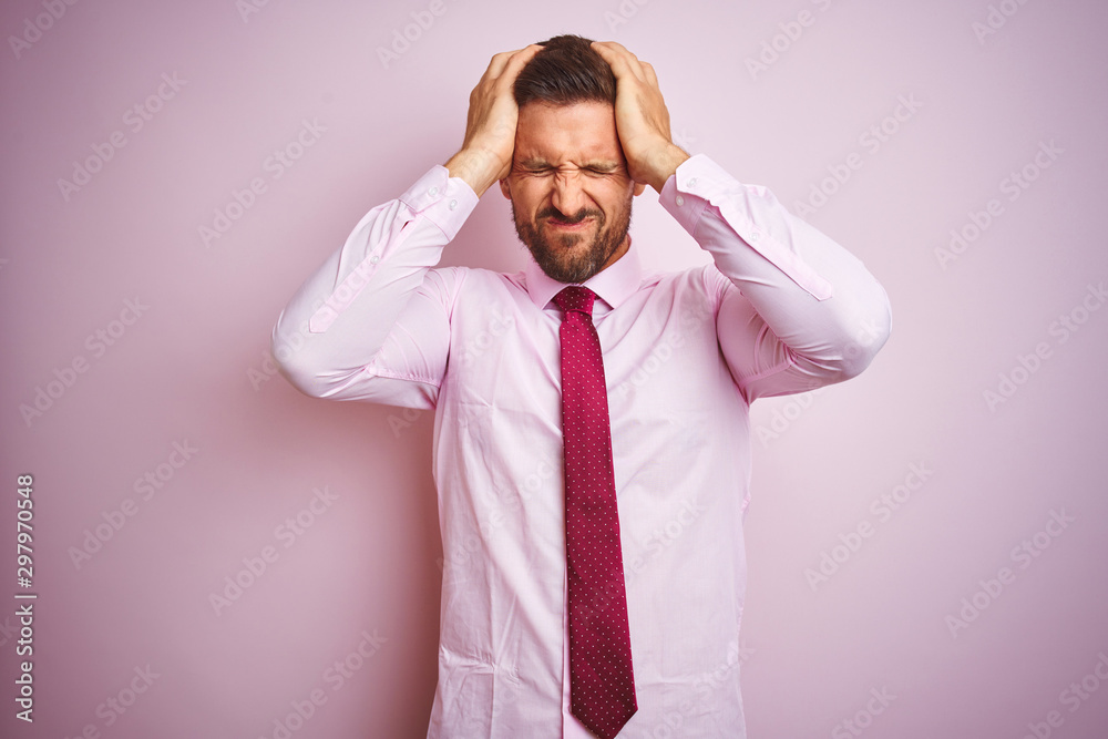 Business man wearing tie and elegant shirt over pink isolated background suffering from headache desperate and stressed because pain and migraine. Hands on head. Business man wearing tie and elegant shirt over pink isolated background suffering from headache desperate and stressed because pain and migraine. Hands on head.