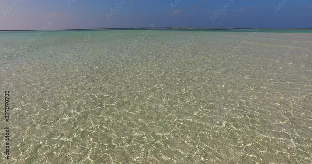 Sunlight reflected on bottom of shallow shore with clear crystal water, under blue violet sky of Caribbean Sunlight reflected on bottom of shallow shore with clear crystal water, under blue violet sky of Caribbean