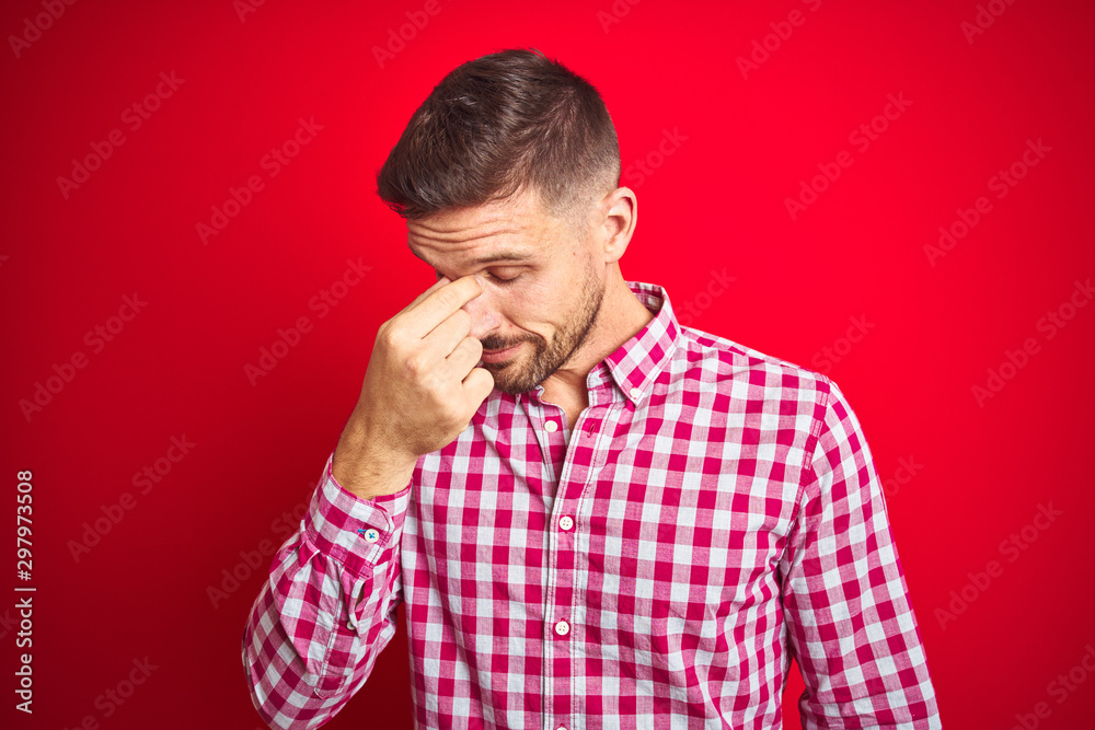 Young handsome man over red isolated background tired rubbing nose and eyes feeling fatigue and headache. Stress and frustration concept. Young handsome man over red isolated background tired rubbing nose and eyes feeling fatigue and headache. Stress and frustration concept.