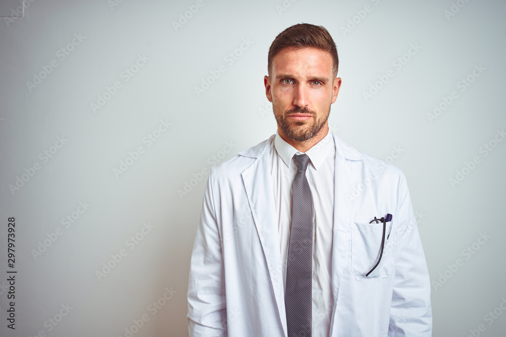 Young handsome doctor man wearing white profressional coat over isolated background skeptic and nervous, frowning upset because of problem. Negative person. Young handsome doctor man wearing white profressional coat over isolated background skeptic and nervous, frowning upset because of problem. Negative person.