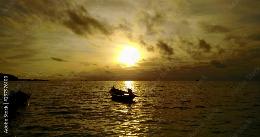 Two fishing boats anchored on island's shore on a beautiful golden sunset with yellow sky in Philippines Two fishing boats anchored on island's shore on a beautiful golden sunset with yellow sky in Philippines