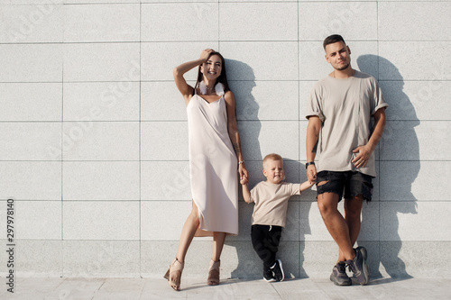 Young family with a child on a walk in the city in summer.Love and trust as family values. Mother and father with son outdoor. Summer vacation of happy family. Child with father and mother. Family wit