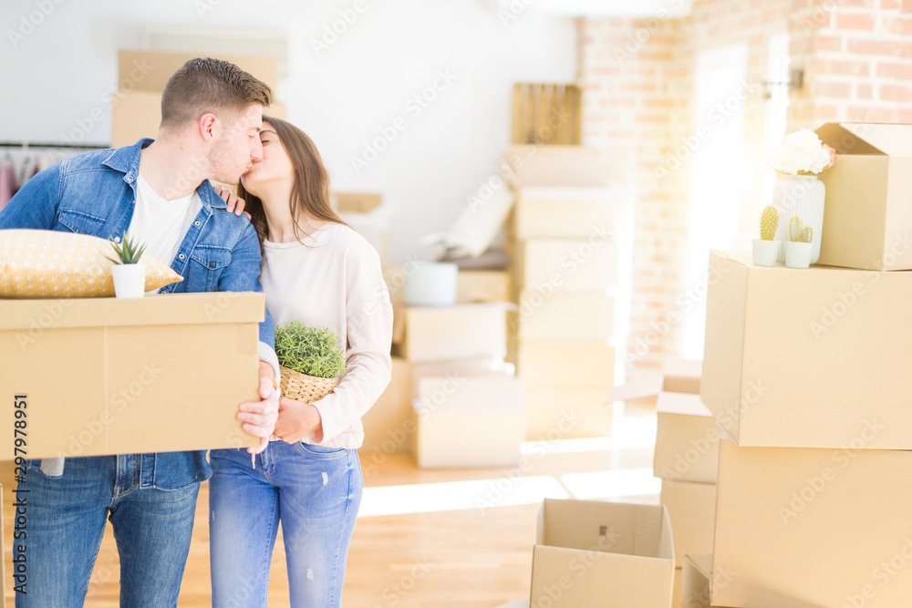 Beautiful young couple smiling in love holding cardboard boxes, happy for moving to a new home Beautiful young couple smiling in love holding cardboard boxes, happy for moving to a new home