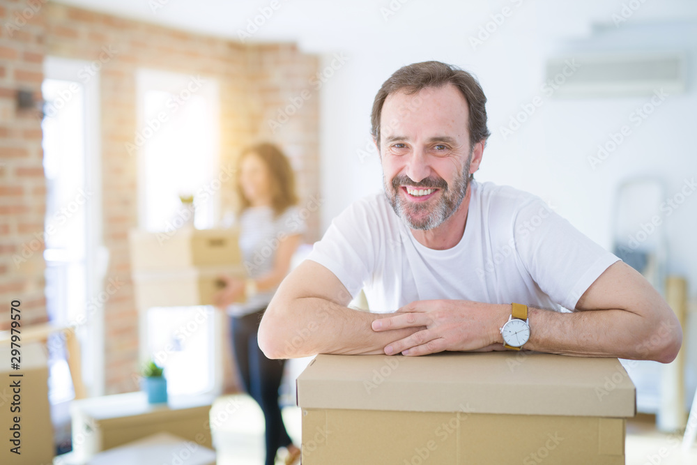 Middle age senior couple moving to a new house, man smiling happy in love with new apartment