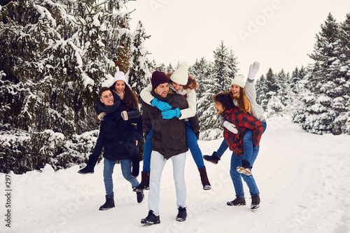 Playful men and women having fun in winter woods