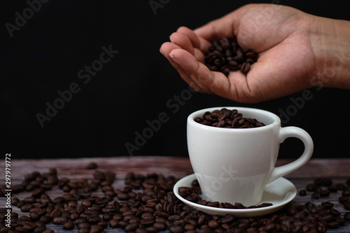 White coffee mugs on a wooden table with coffee beans on the floor.