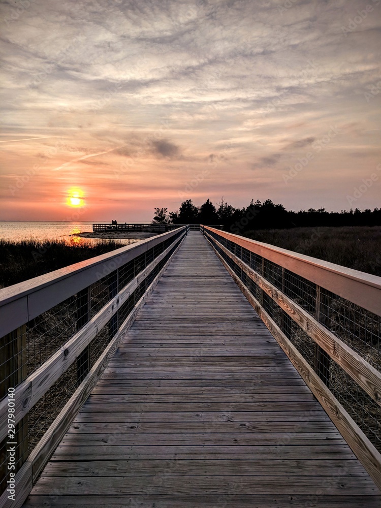 Cloudy sunset by boardwalk and water