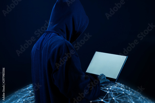 Anonymous hacker with laptop in the dark. Cyber security concept