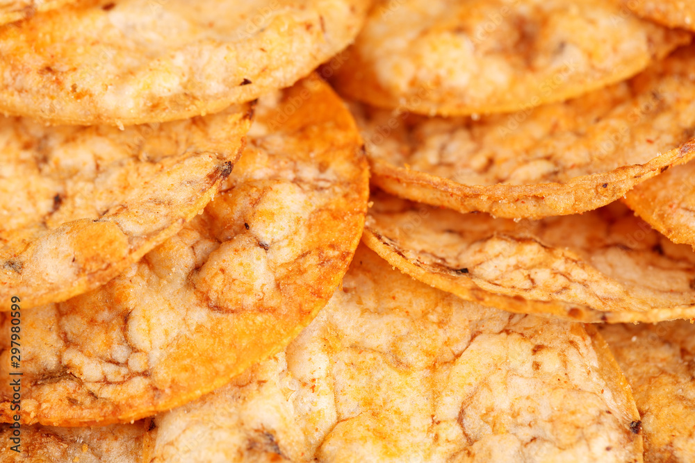 Extreme close up of a pile of organic, crispy, baked, whole grain rice chips with tomato and paprika spices. Gluten free healthy snack. Macro food background. Extreme close up of a pile of organic, crispy, baked, whole grain rice chips with tomato and paprika spices. Gluten free healthy snack. Macro food background.