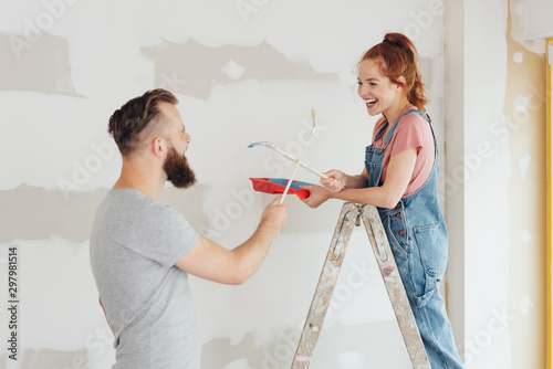 Fotografie Laughing young couple fooling around with paint