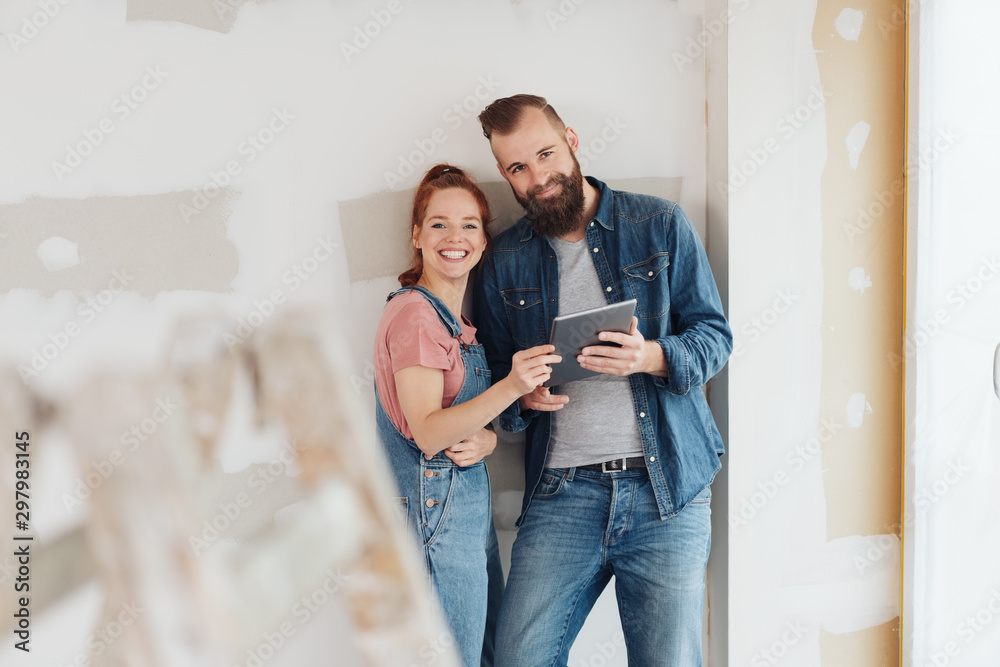 Happy friendly couple redecorating their house Happy friendly couple redecorating their house