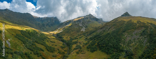 Panorama of mountain terrain in early autumn  amazing dramatic clouds on mountain peaks  rivers cutting gorges and canyones in valleys  natural outdoor travel background  sunny day on Caucasus © Maria Shaytor