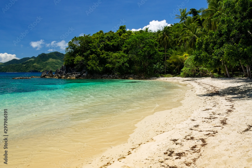 Turquoise and clear waters on the west side of the white sand Tuninon beach in Guijalo, municipality of Caramoan, Camarines Sur Province, Luzon, Philippines. Turquoise and clear waters on the west side of the white sand Tuninon beach in Guijalo, municipality of Caramoan, Camarines Sur Province, Luzon, Philippines.