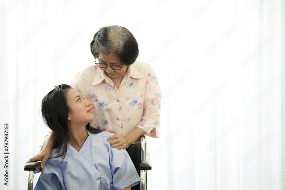 Asian old woman doctor are take care girl patient sit on wheel chair in hospital Asian old woman doctor are take care girl patient sit on wheel chair in hospital