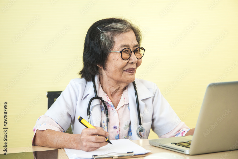 Old professional doctor are working the job on the table with laptop in the hospital Old professional doctor are working the job on the table with laptop in the hospital