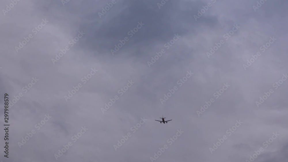 Aircraft is flying in cloudy sky over the head. White passenger plane. Aircraft is flying in cloudy sky over the head. White passenger plane.