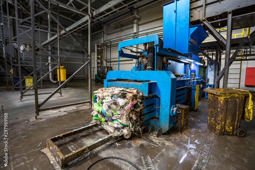 Equipment for pressing debris sorting material to be processed in modern waste recycling plant. garbage press on modern waste recycling processing plant. Business for sorting and processing of waste.