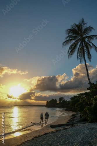 Couple marchant sur la plage au coucher de soleil, Guadeloupe, France