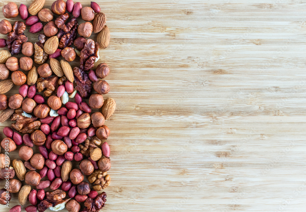 Mix of nuts: pistachio, almond, hazelnut, peanut, walnut fill the left part of the image, the right part is empty Mix of nuts: pistachio, almond, hazelnut, peanut, walnut fill the left part of the image, the right part is empty