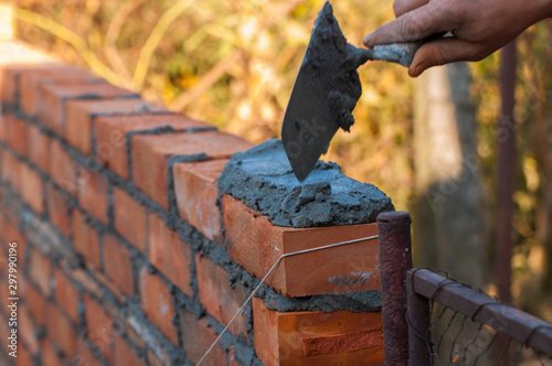 Obraz na plátně Building a wall with red brick