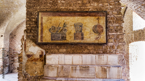 Roman empire archaeological excavations in Ostia Antica with the interior of the Termopolio s tenement and the marble shelf surmounted with decorative still life frescoes photo