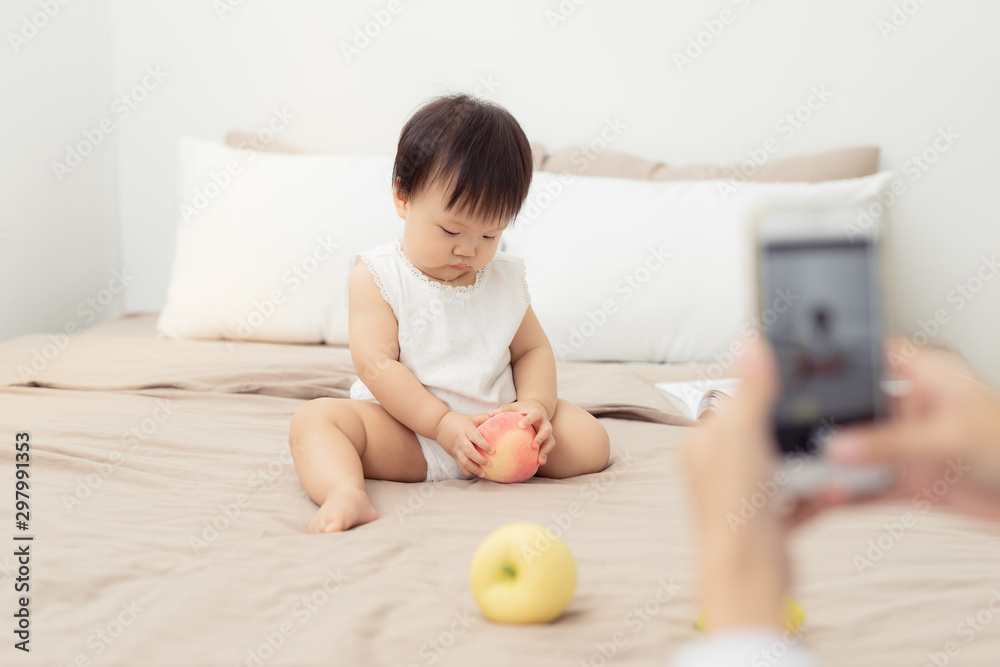 Cute baby playing with toy on bed. Kid playing at home Cute baby playing with toy on bed. Kid playing at home
