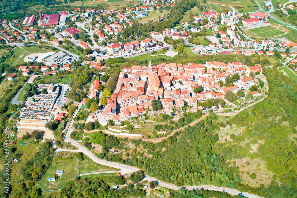 Buzet. Hill town of Buzet surrounded by stone walls in green landscape aerial view
