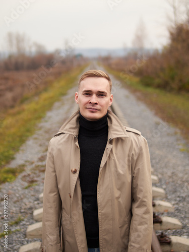 Autumn mood, young guy in a raincoat trench coat underground, street style.
