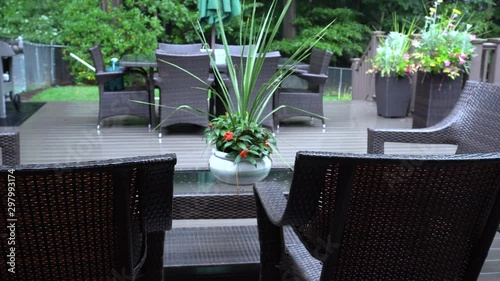 Rain lightly pattering on a suburban deck during a summer storm with a cold/cool look. Filmed in 4k at 24 fps. photo