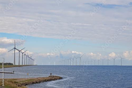 Rows of windmills standing in the sea.