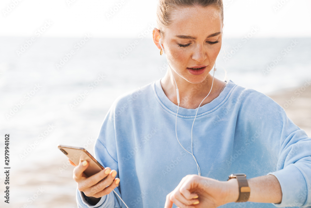 Woman outdoors on beach using mobile phone