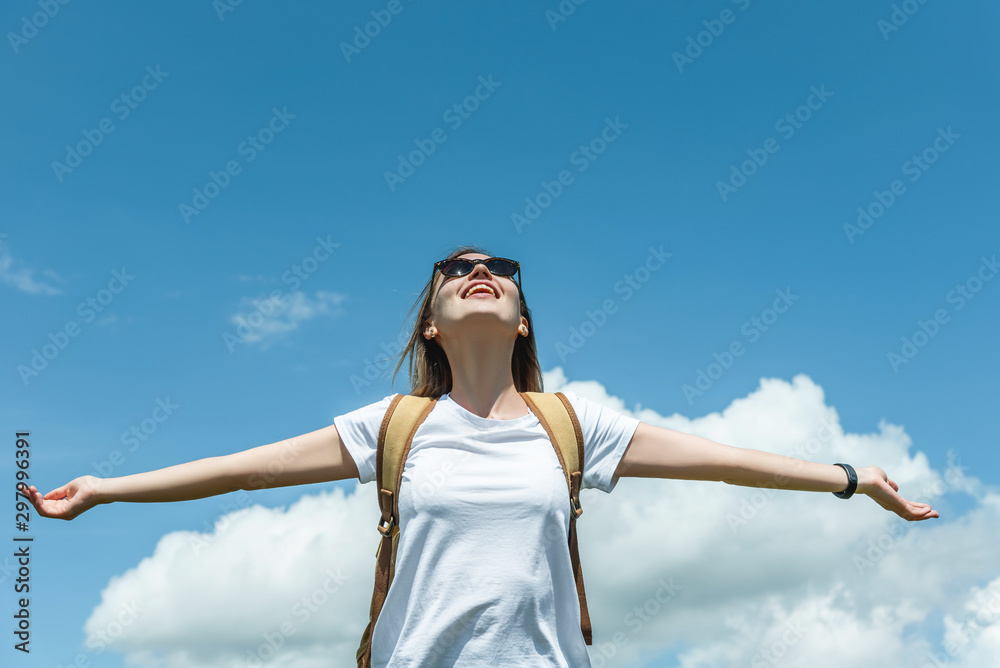 A young girl, arms outstretched, stands in the mountains against the sky. A young girl, arms outstretched, stands in the mountains against the sky.