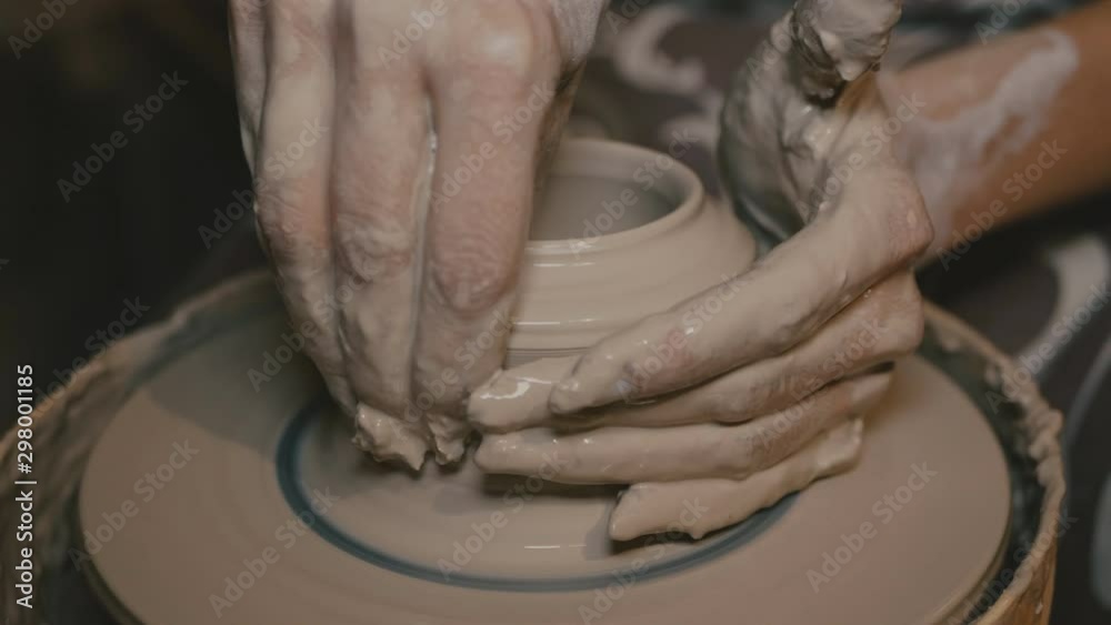 the potter forms an earthenware product on a pottery wheel. hands of a ...