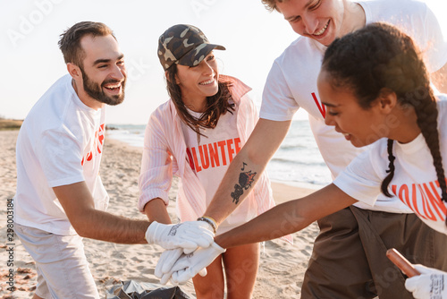 Image of smiling teamwork volunteers holding hands together photo