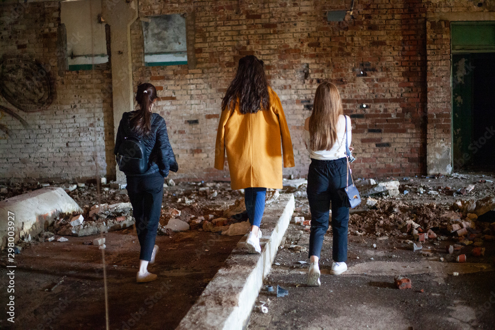 Teenage girls are walking around the ghetto. Girls in an abandoned building hide from their parents. Girls are looking for adventure.