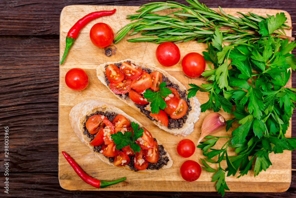 Fresh tasty bruschetta with truffle sauce, parsley and tomates. Top view