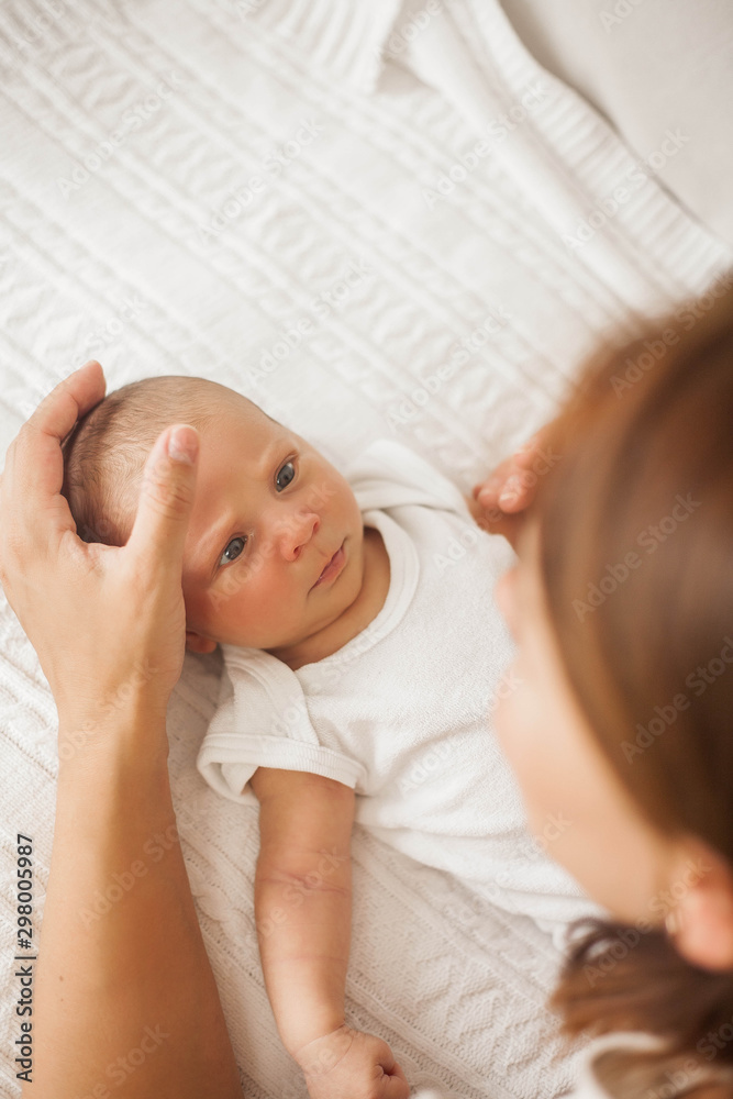 Beautiful young mother plays with the baby in bed. Motherhood. Beautiful young mother plays with the baby in bed. Motherhood.
