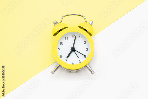 Yellow clock on yellow and white background