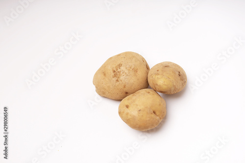 Three fresh brown potatoes raw isolated white background