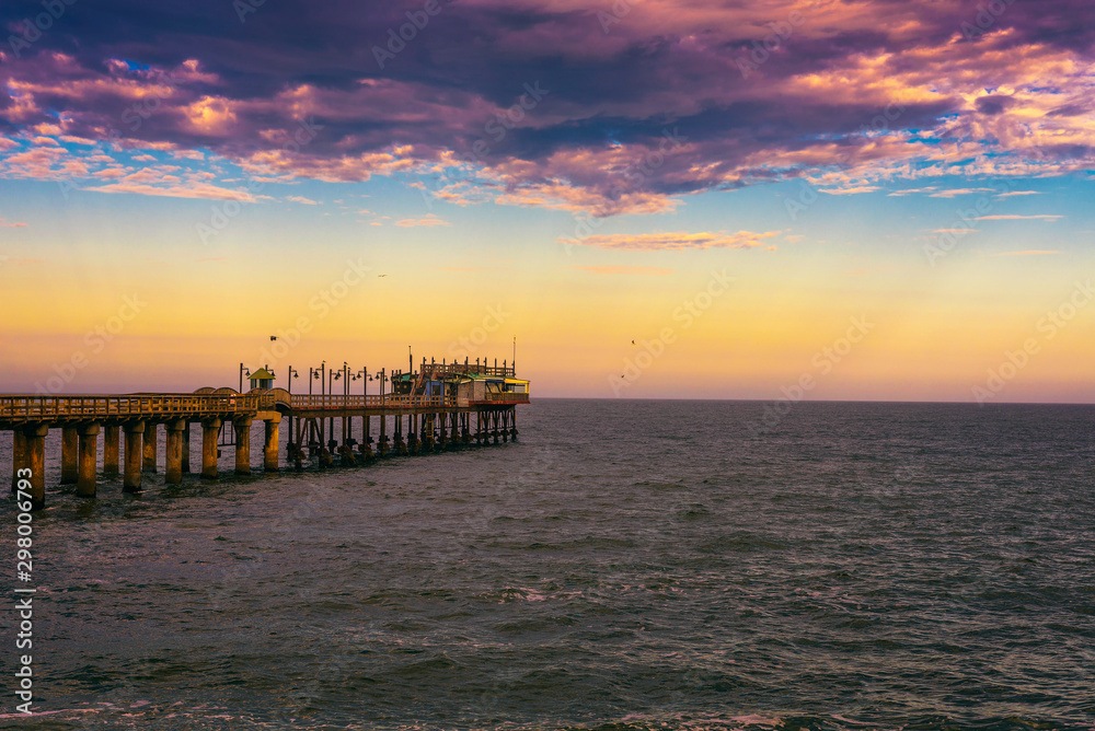 Fototapeta premium Sunset over the old historic jetty in Swakopmund, Namibia