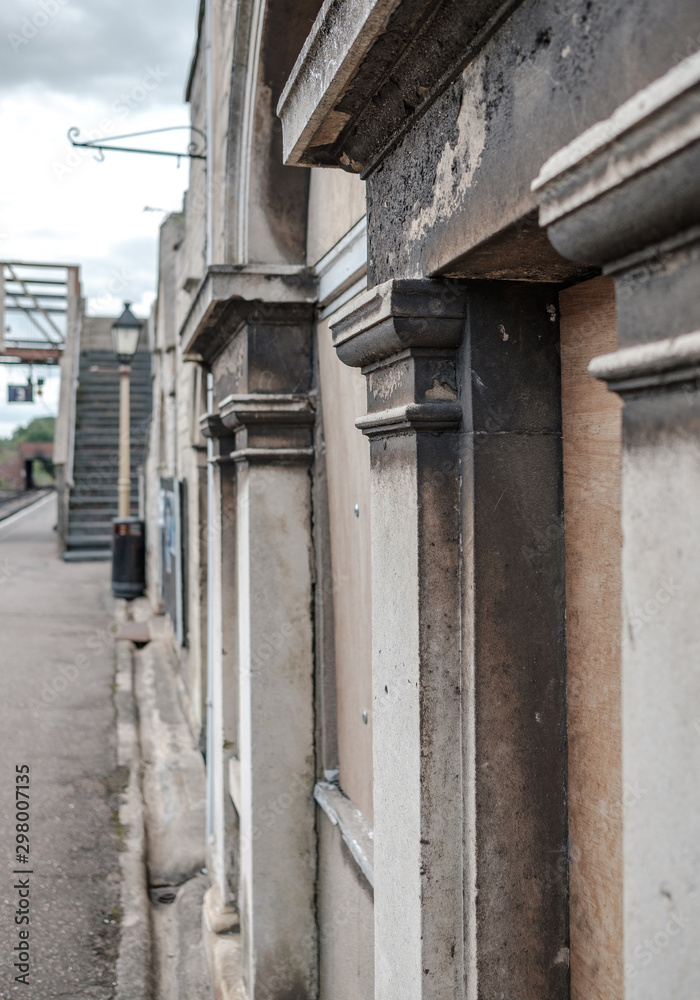 Obraz premium Close-up, architectural view of an victorian railway station, seen on the station platform. The building shows sign smoke blacking and weathering.