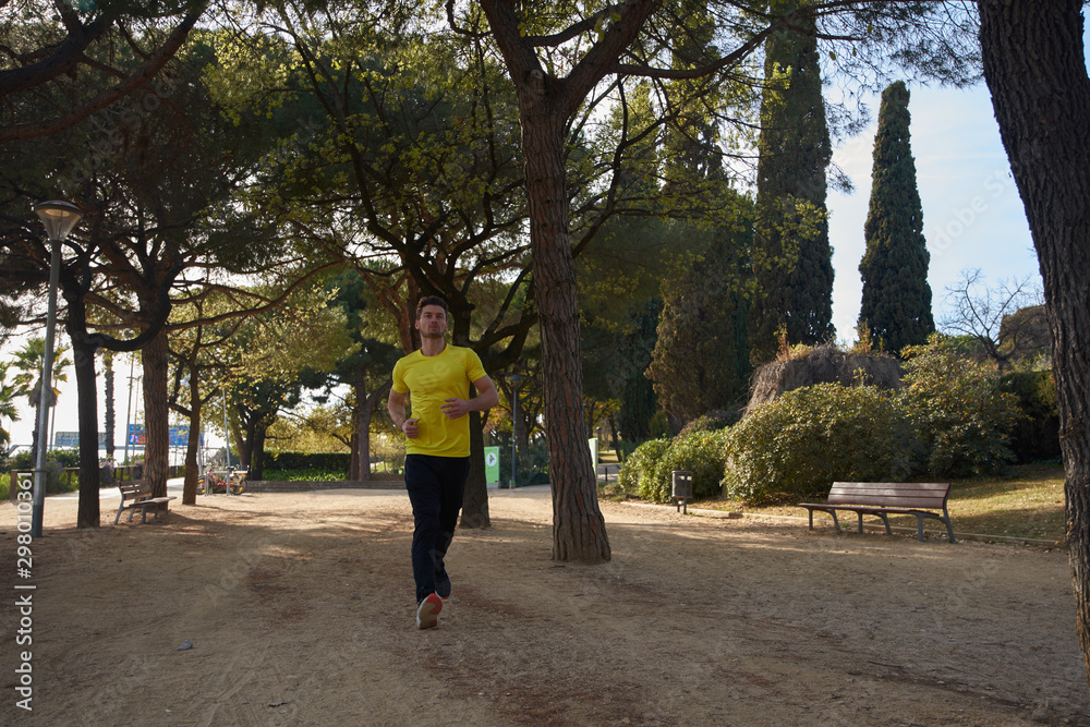 Fototapeta premium Man in a yellow shirt running through the trees